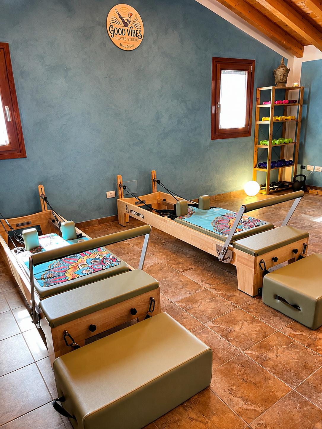 I due Reformer e i piccoli attrezzi nello studio Good Vibes, sotto il logo sulla parete azzurra